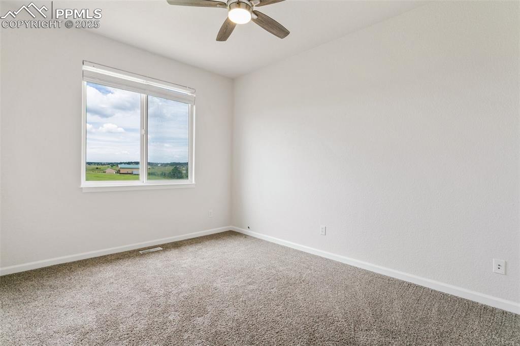 Image 26 of 44: Empty room featuring carpet and ceiling fan