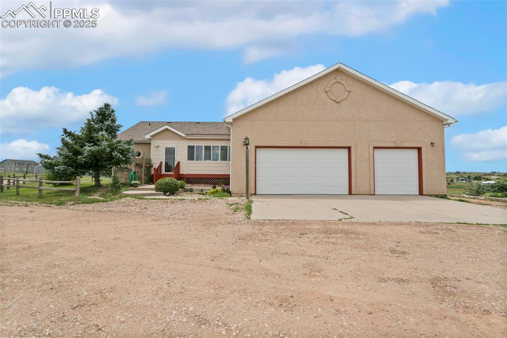 Image 38 of 44: Single story home with stucco siding, a garage, and driveway