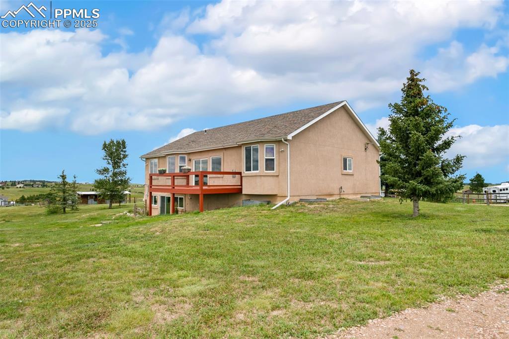 Image 41 of 44: Back of house featuring a wooden deck, stucco siding, and a shingled roof