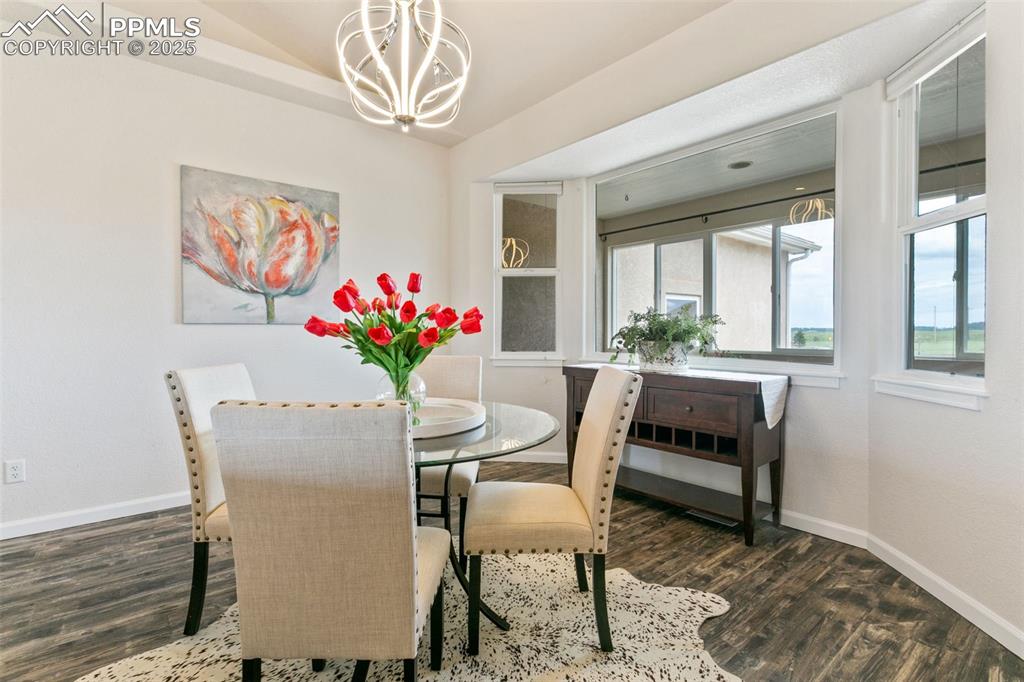 Image 7 of 44: Dining area featuring a chandelier and wood finished floors