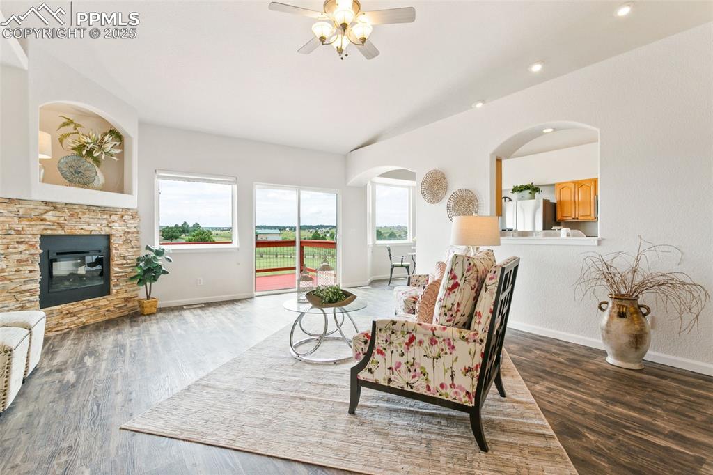 Image 9 of 44: Living area featuring a ceiling fan, wood finished floors, a fireplace, rec