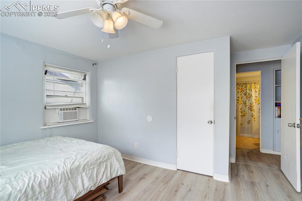 Image 17 of 28: Bedroom with light wood-style flooring, ceiling fan, and cooling unit