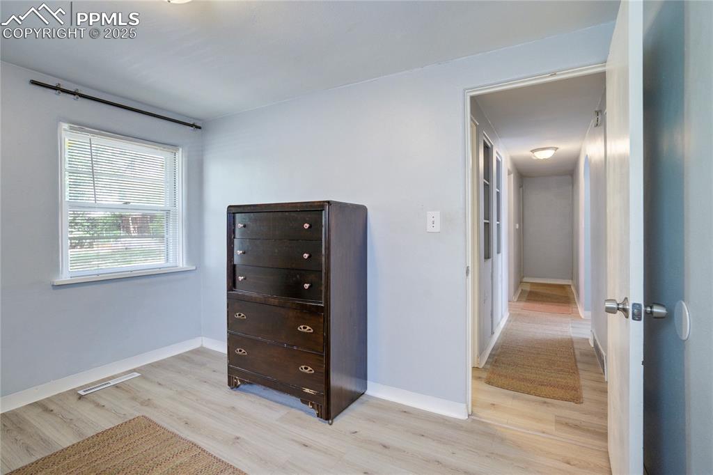 Image 19 of 28: Bedroom with light wood-type flooring and attic access