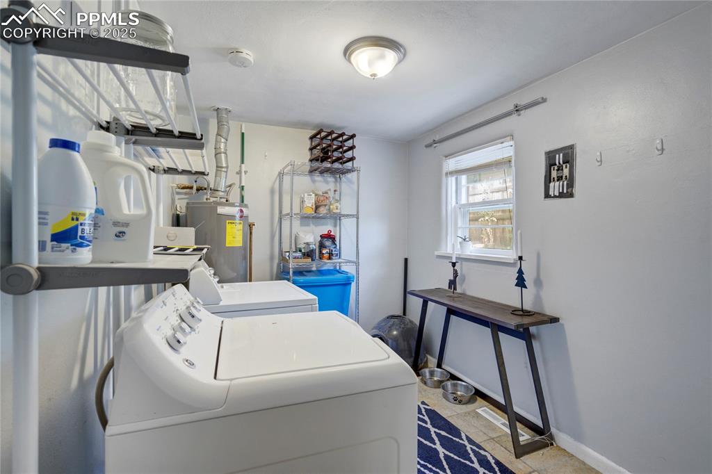 Image 20 of 28: Washroom with washing machine and dryer and water heater