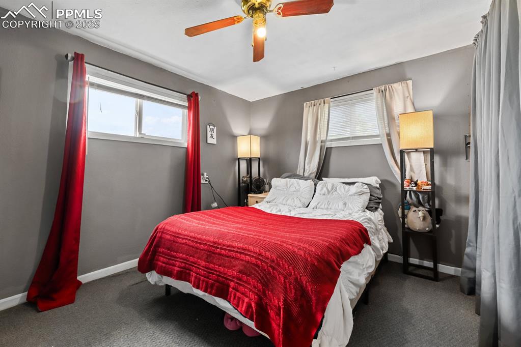 Image 12 of 24: Bedroom with a ceiling fan and carpet flooring