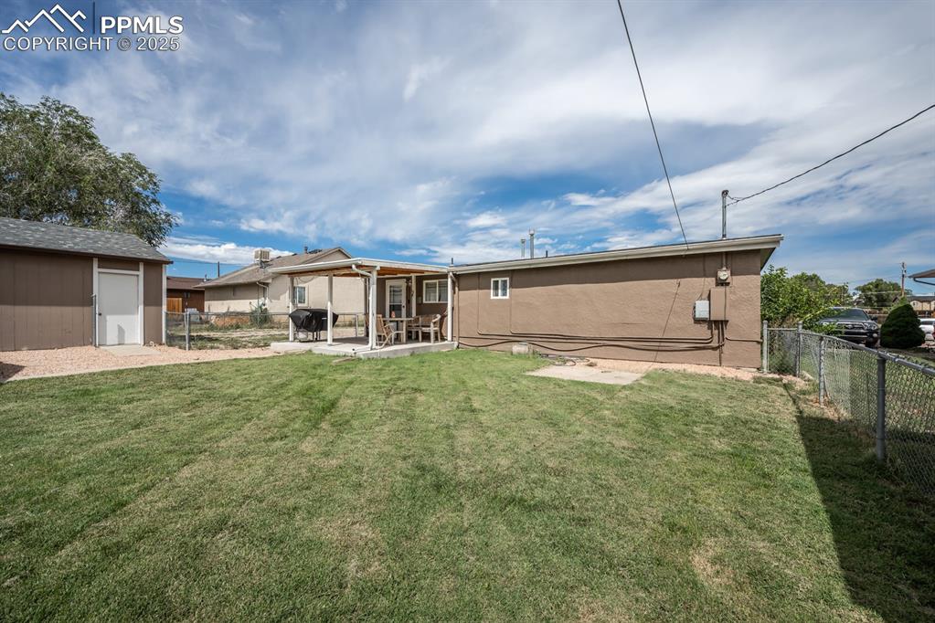 Image 22 of 24: Rear view of property with a fenced backyard, a patio, and a storage shed