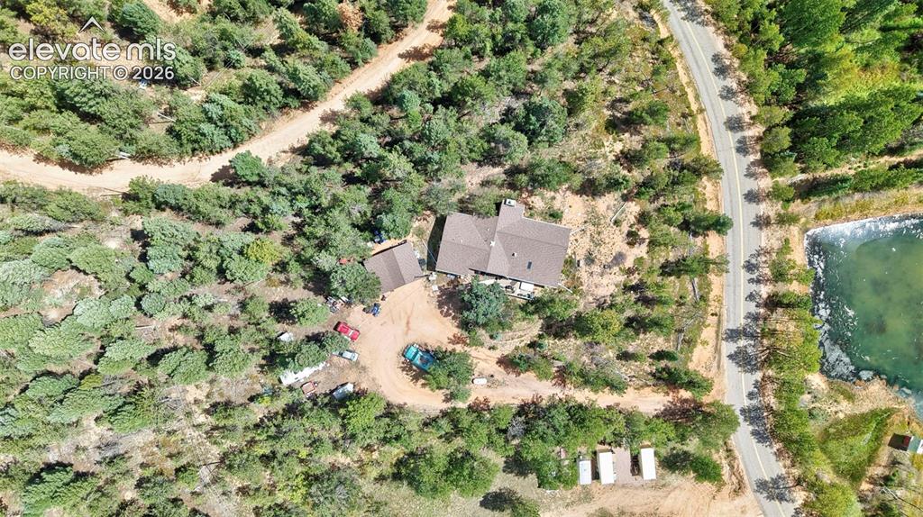 Image 4 of 21: Expansive property featuring a main residence with an detached garage, surr