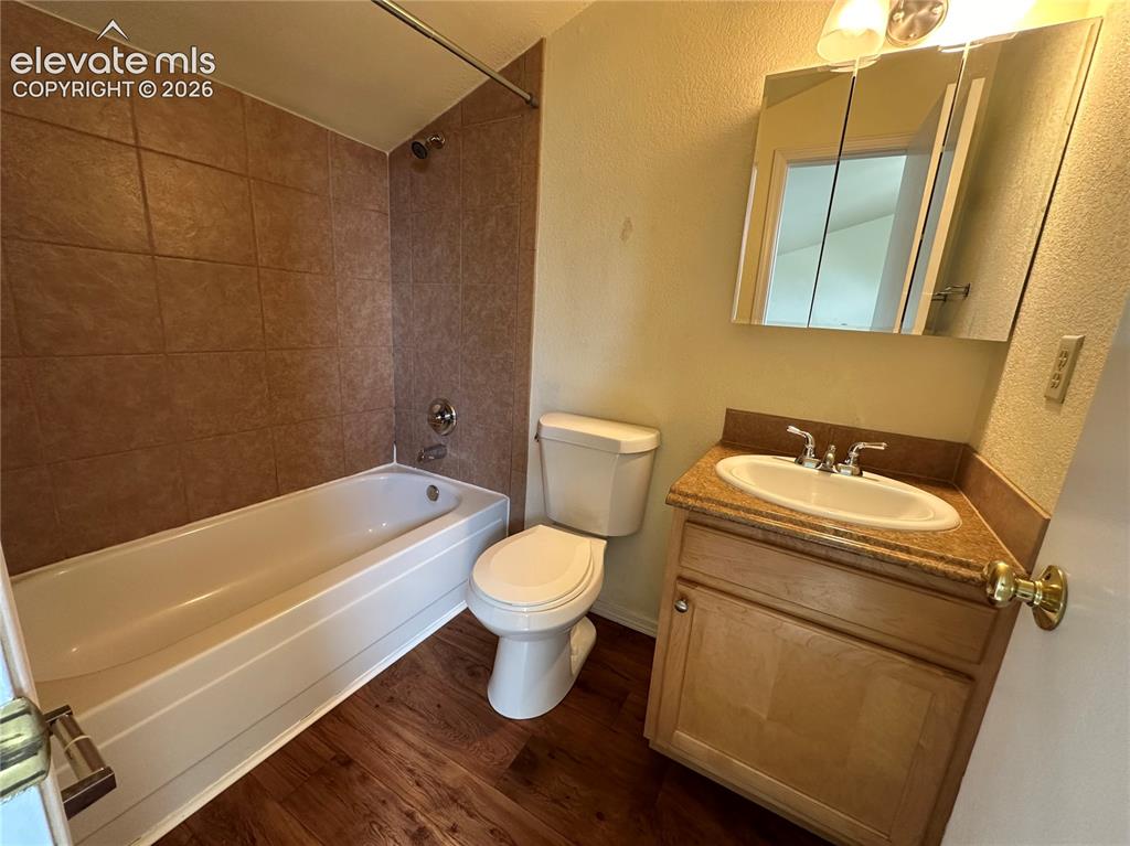 Image 10 of 12: Full bathroom featuring a tub/shower combination with brown tile surround, 