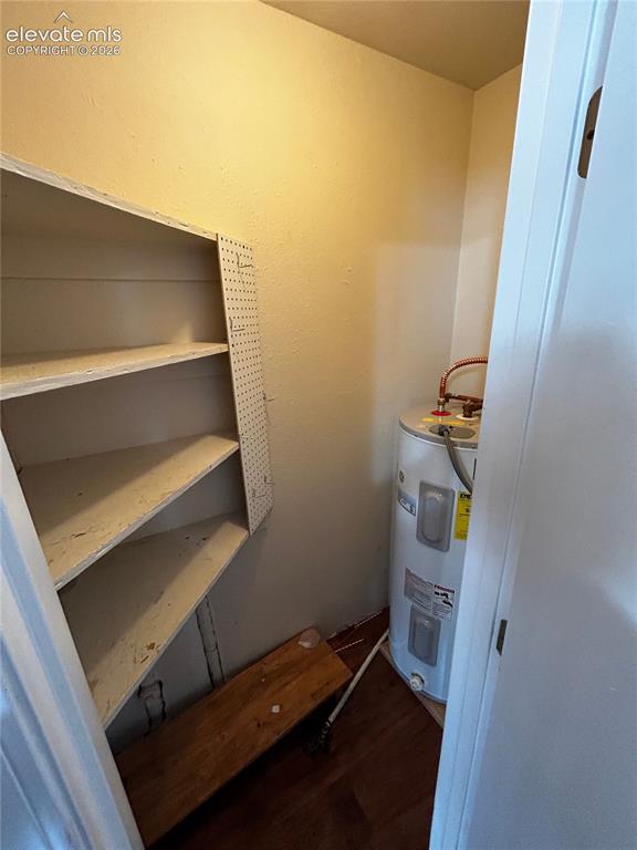 Image 9 of 12: Utility closet with water heater and built-in shelving