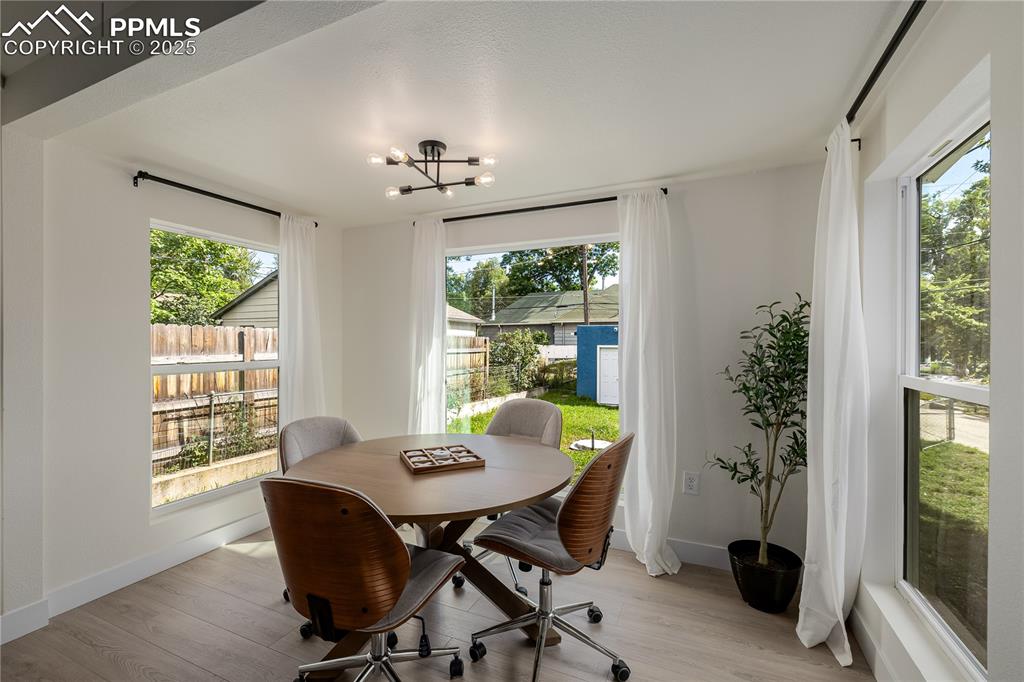 Image 15 of 39: Dining area with light wood-type flooring, a chandelier, and plenty of natu
