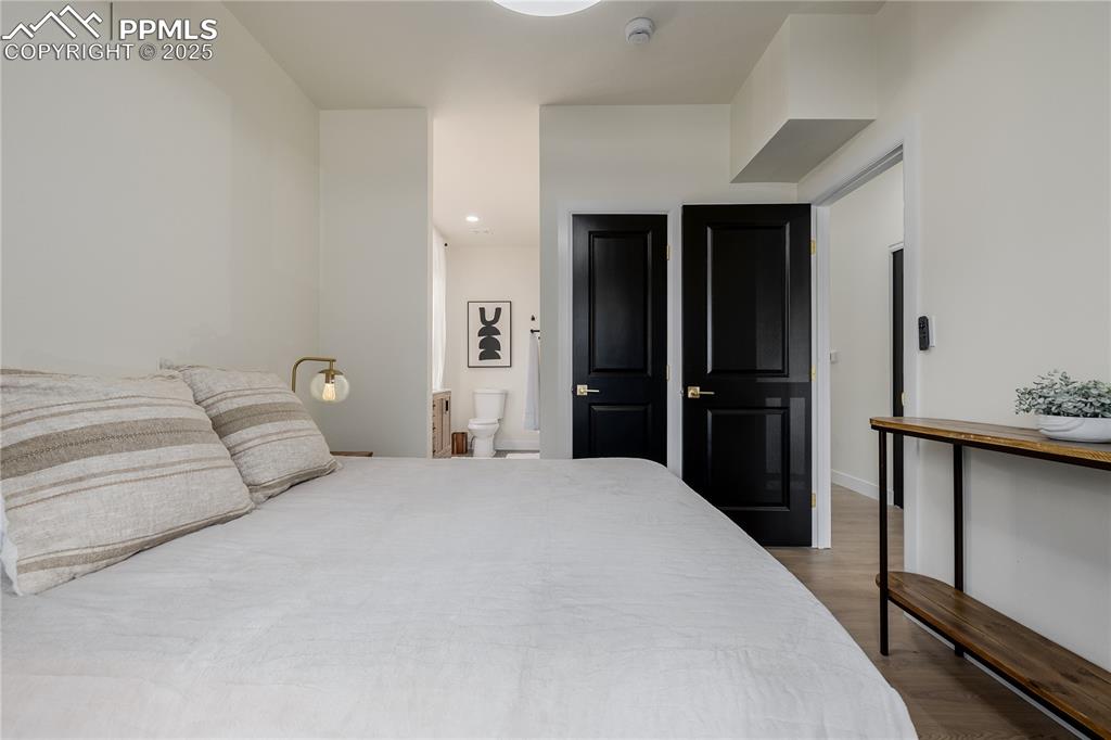 Image 22 of 39: Bedroom with dark wood-type flooring and recessed lighting