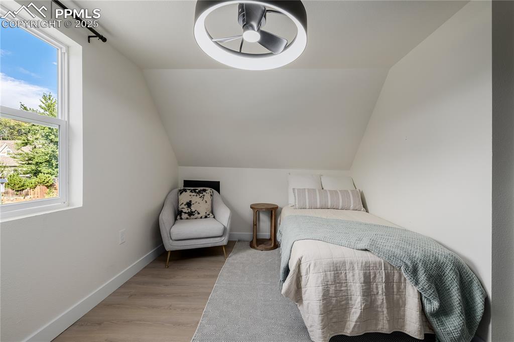 Image 24 of 39: Bedroom featuring light wood finished floors and vaulted ceiling