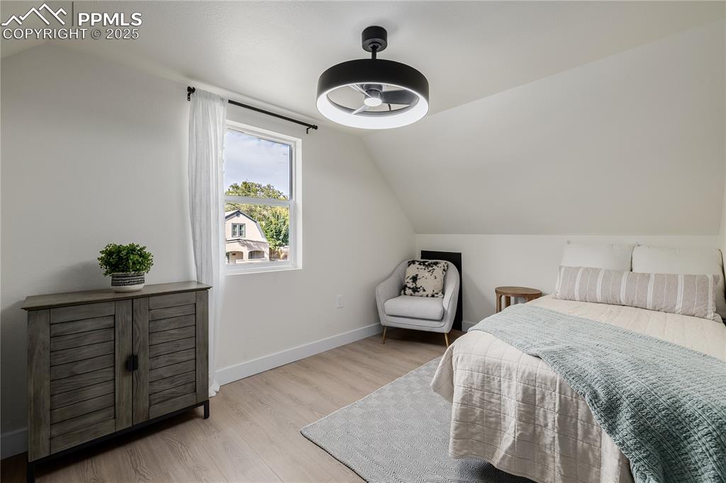 Image 25 of 39: Bedroom featuring vaulted ceiling and wood finished floors