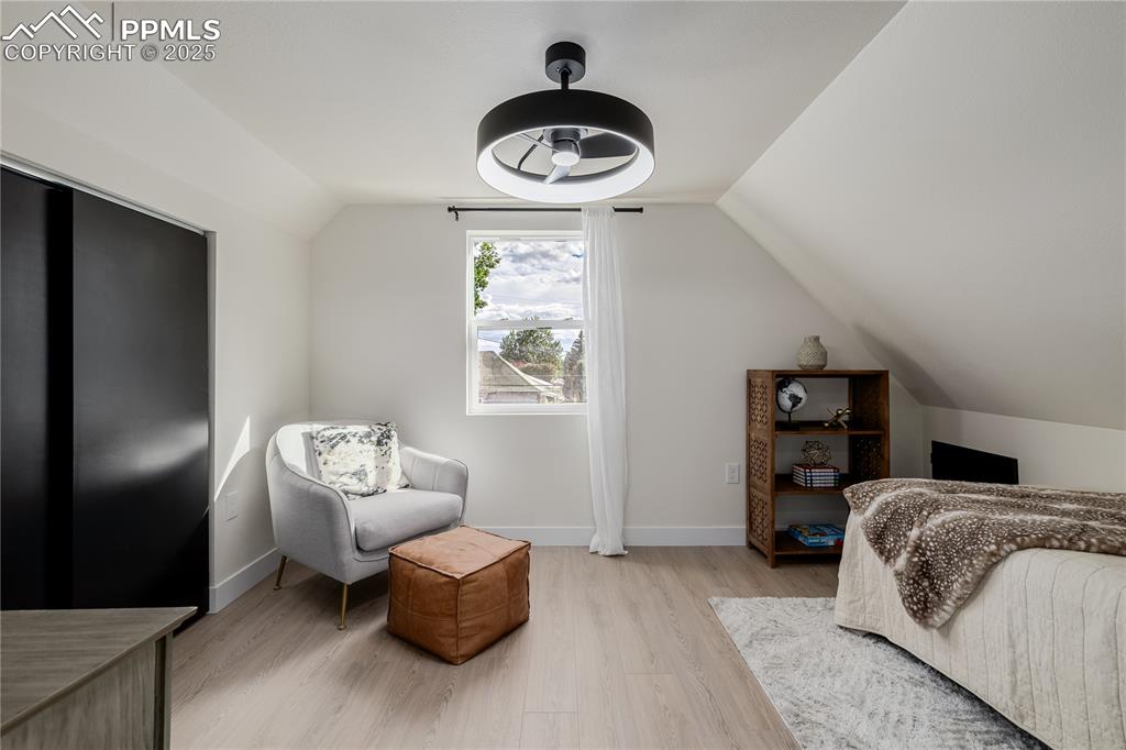 Image 29 of 39: Bedroom with lofted ceiling and light wood-style floors