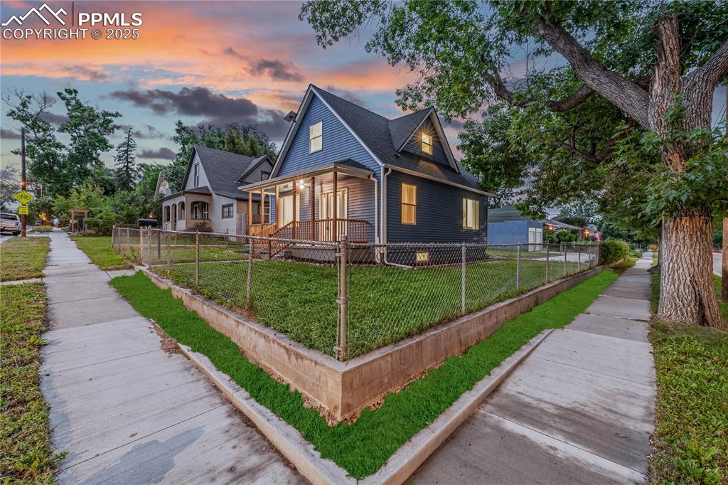 Image 3 of 39: View of front of house featuring a porch, a fenced front yard, and roof wit