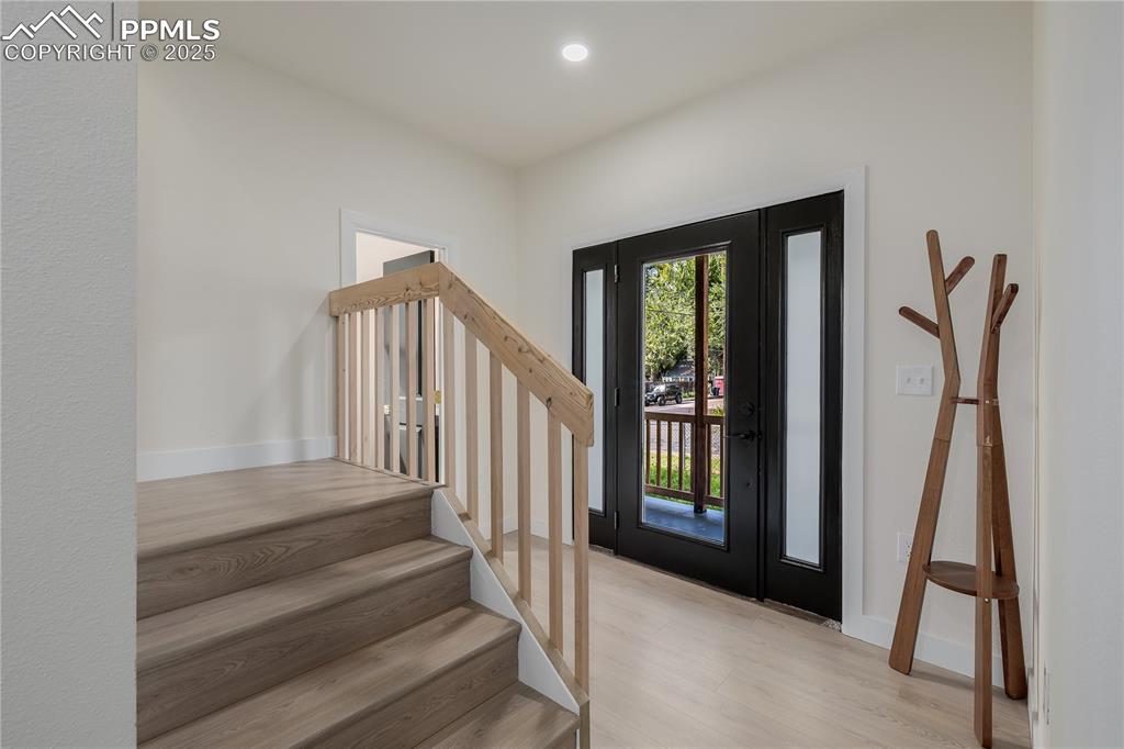 Image 4 of 39: Foyer entrance with light wood-type flooring, stairs, and recessed lighting