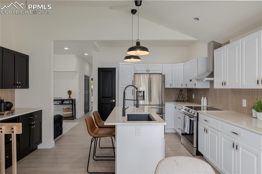 Image 9 of 39: Kitchen with appliances with stainless steel finishes, decorative light fix