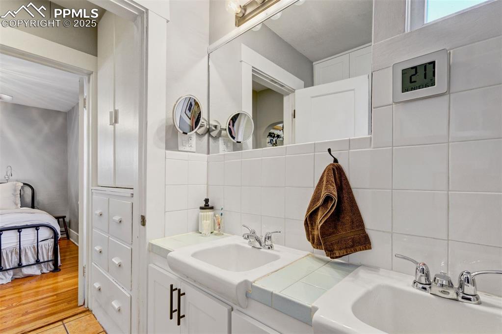 Image 23 of 49: Bathroom featuring tasteful backsplash, vanity, ensuite bathroom, and light