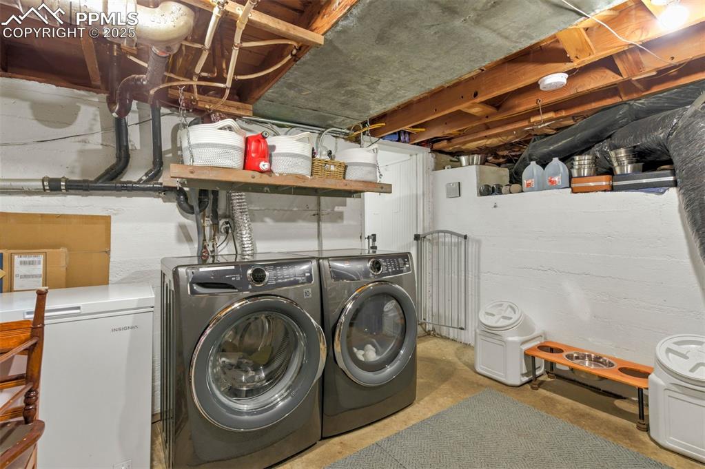 Image 31 of 49: Laundry room featuring unfinished concrete flooring and washing machine and