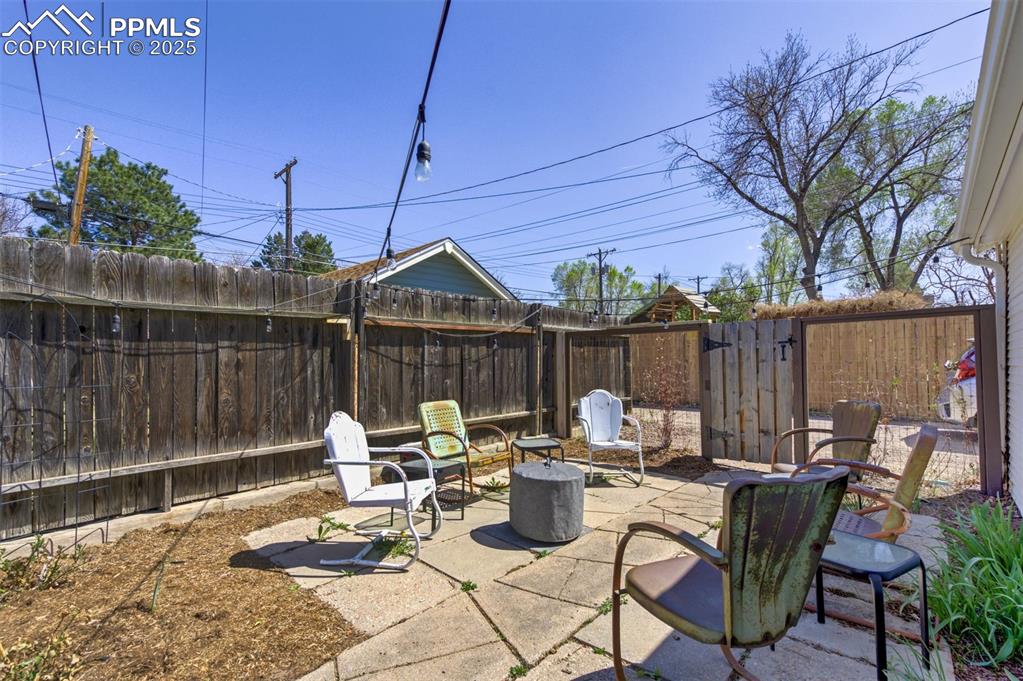 Image 33 of 49: Fenced backyard featuring a patio and a fire pit