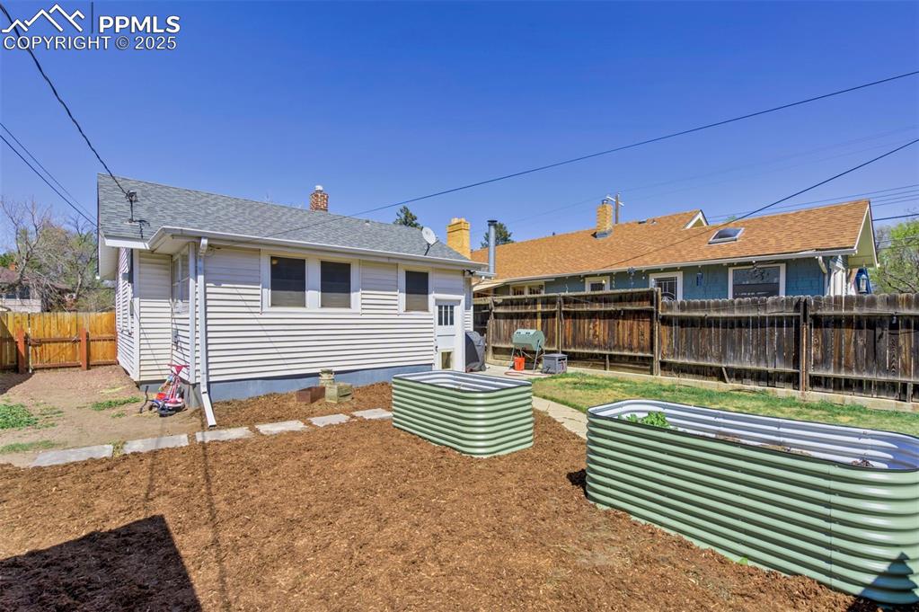 Image 42 of 49: Rear view of property with a fenced backyard, a chimney, and a shingled roo