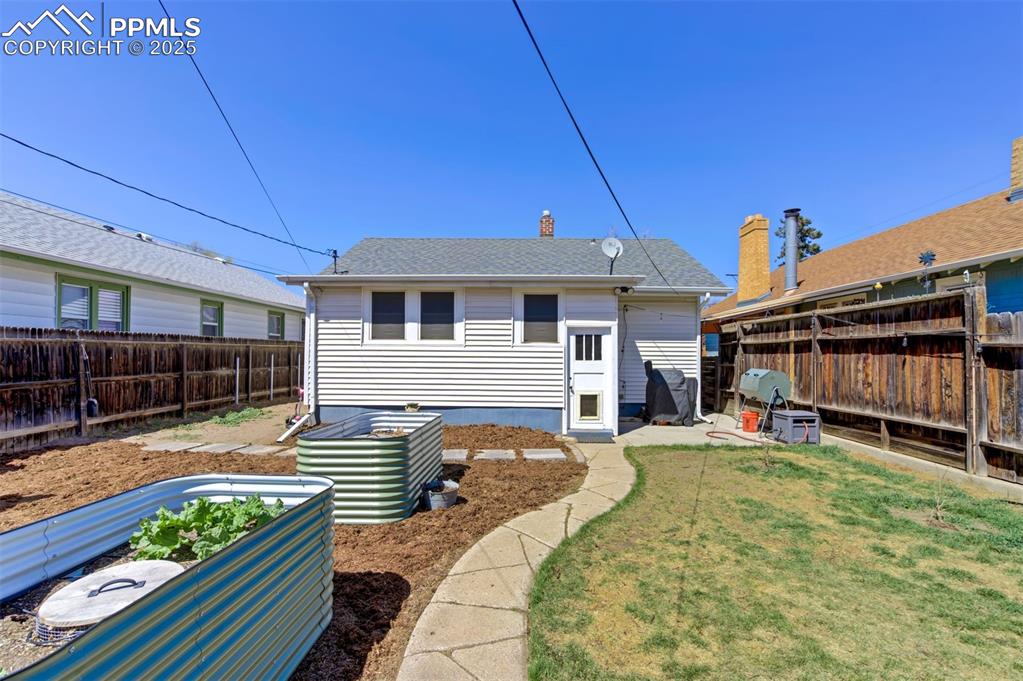 Image 43 of 49: Rear view of property with a garden and a fenced backyard