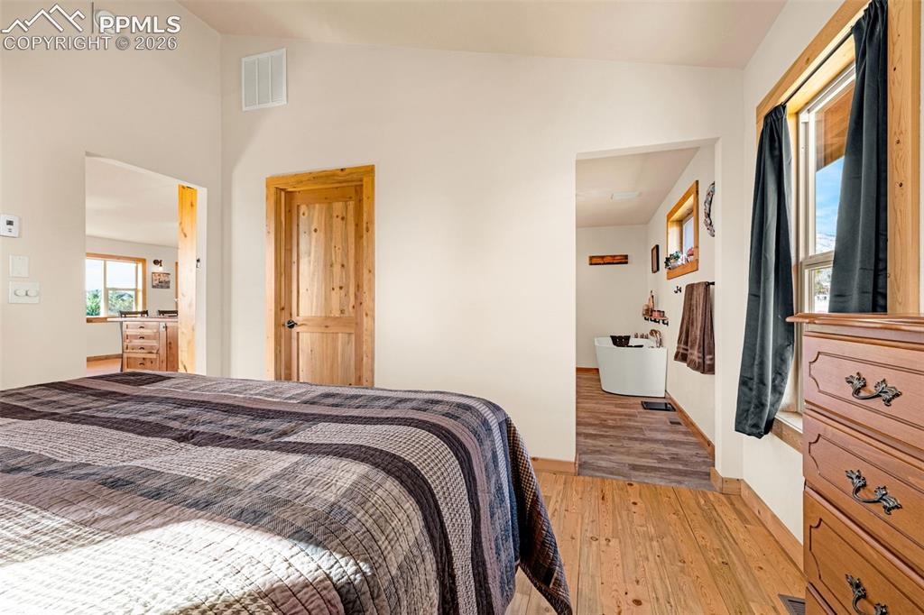 Image 12 of 50: Bedroom featuring lofted ceiling and light wood-type flooring