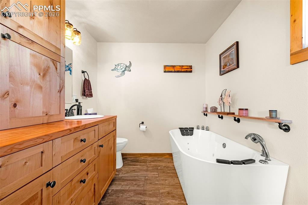 Image 14 of 50: Primary bathroom with jetted tub and double vanity