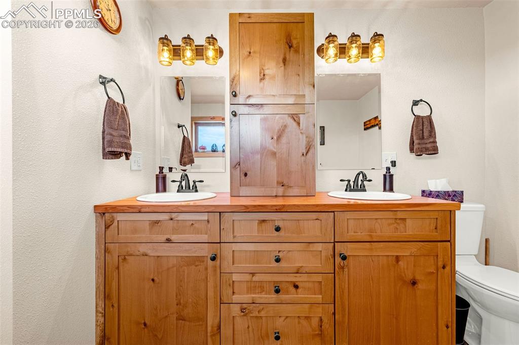 Image 16 of 50: Bathroom featuring double vanity and toilet
