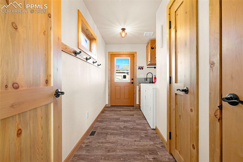 Image 19 of 50: Laundry room located on main level with side entry door