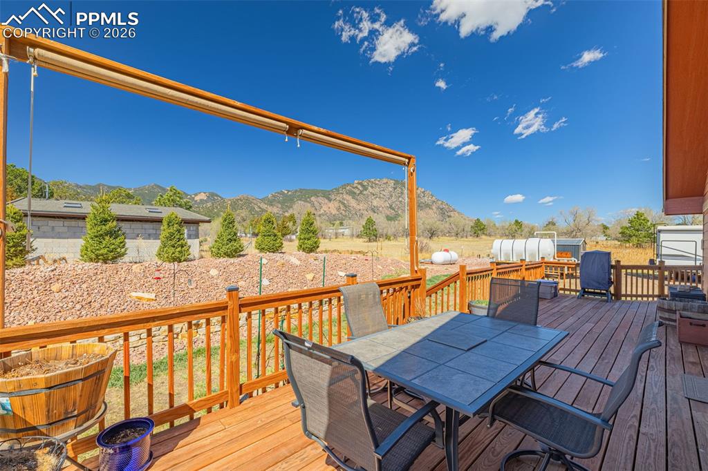 Image 30 of 49: Wooden deck with outdoor dining space and a mountain view
