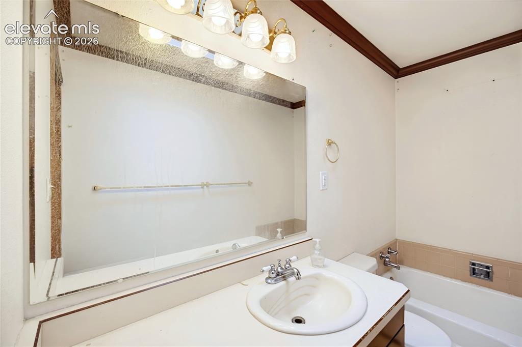 Image 11 of 45: Vanity with integrated sink, chrome-finish faucet, and expansive wall-mount