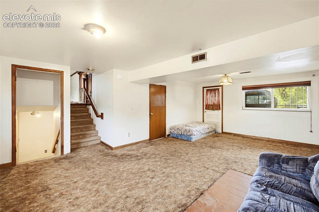 Image 19 of 45: Carpeted room featuring a window, overhead lighting, and interior doorways
