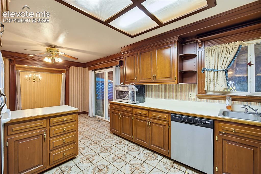 Image 23 of 45: Kitchen featuring wood-finish cabinetry, patterned flooring, a ceiling fan,