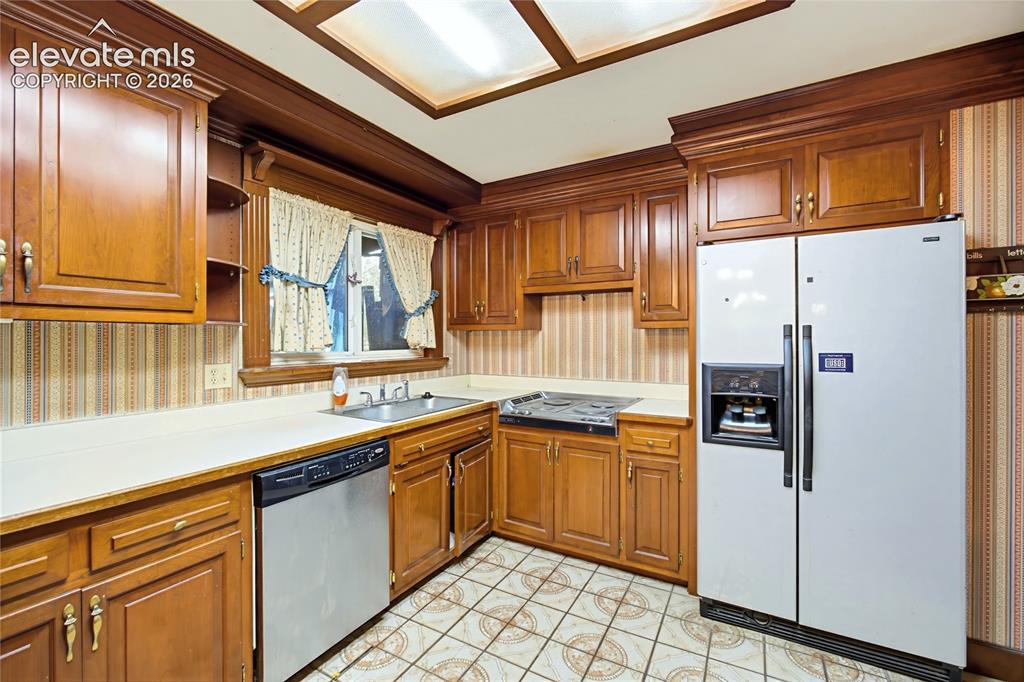Image 25 of 45: Kitchen featuring wood cabinetry, light-toned countertops, a stainless stee