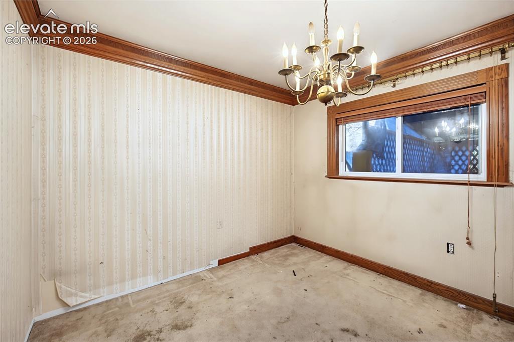 Image 30 of 45: Brass chandelier, wood window trim, wood crown molding, wood baseboards, si