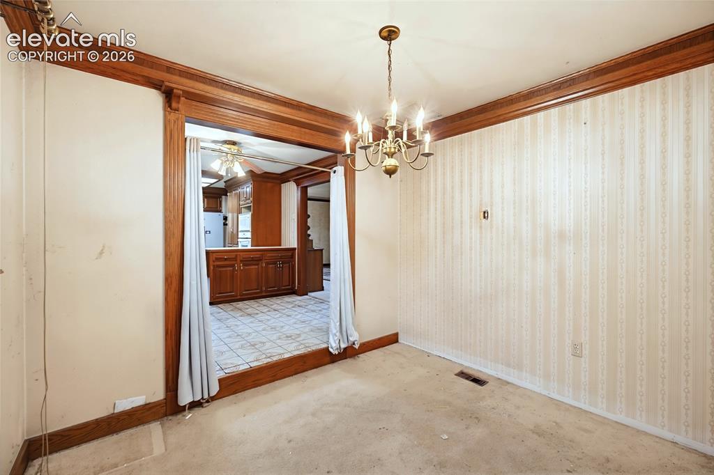 Image 32 of 45: Brass chandelier and extensive wood trim accents