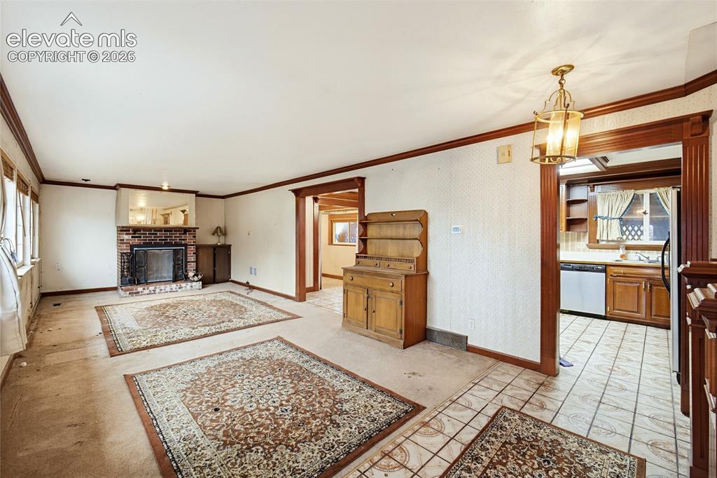 Image 34 of 45: Brick fireplace with mirrored mantel, wood trim detailing, recessed window,