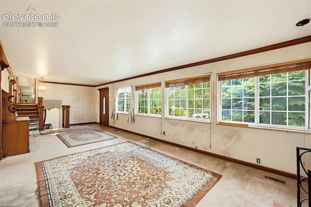 Image 36 of 45: Spacious room with multiple grid-paned windows, wood trim, and a built-in s