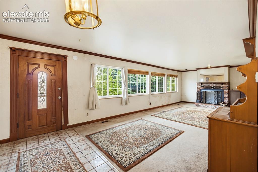 Image 37 of 45: Entryway featuring a decorative wood door with leaded glass, tile flooring,