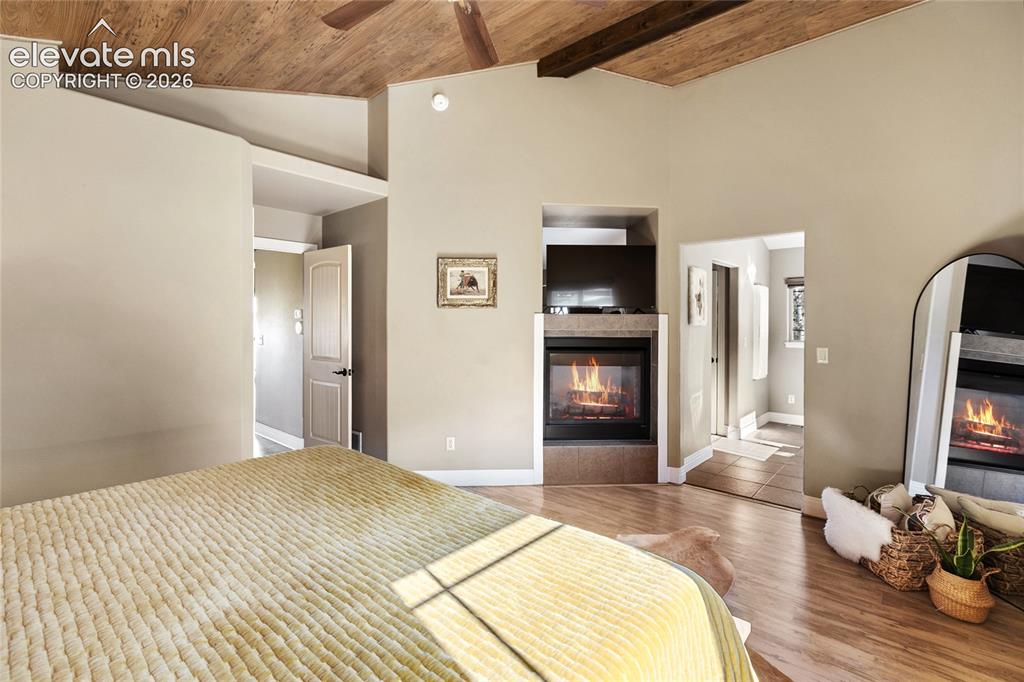 Image 17 of 30: Primary with dual sided fireplace, en suite to 5 piece bath and private lau