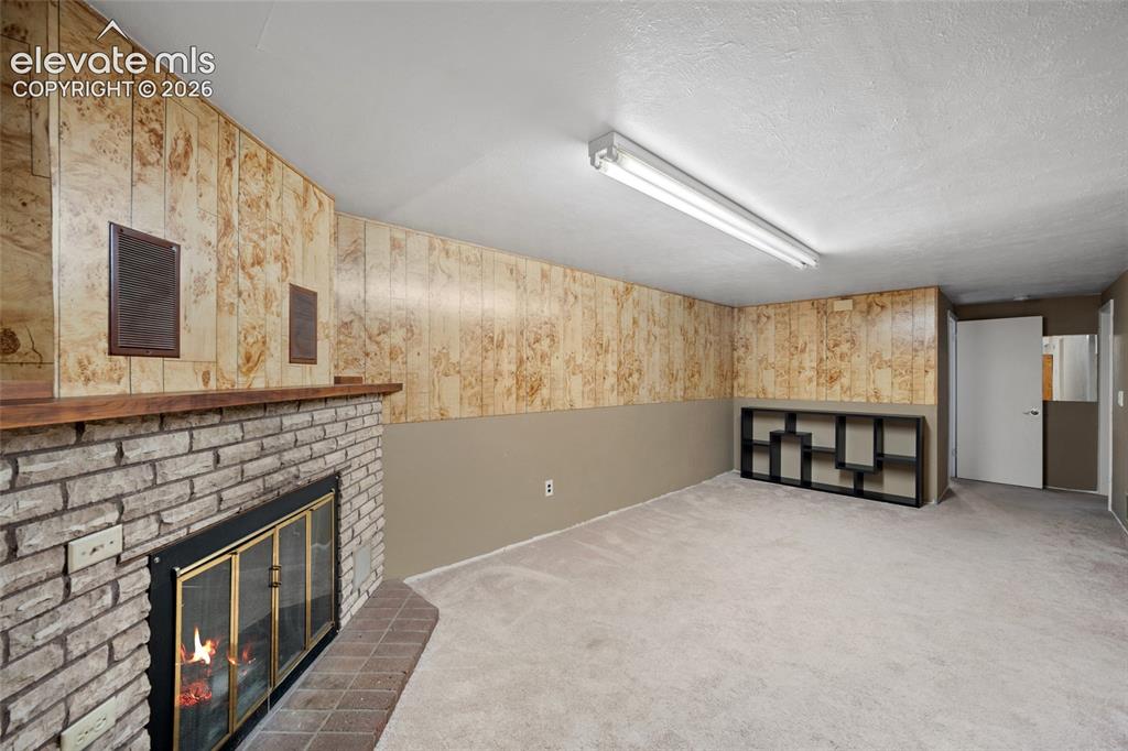 Image 15 of 41: Basement Recreation Room with Wood-Burning Fireplace