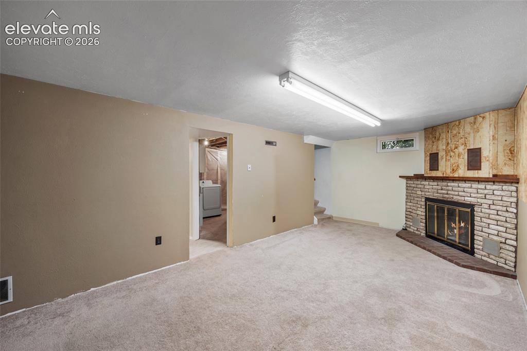 Image 16 of 41: Basement Recreation Room with Wood-Burning Fireplace