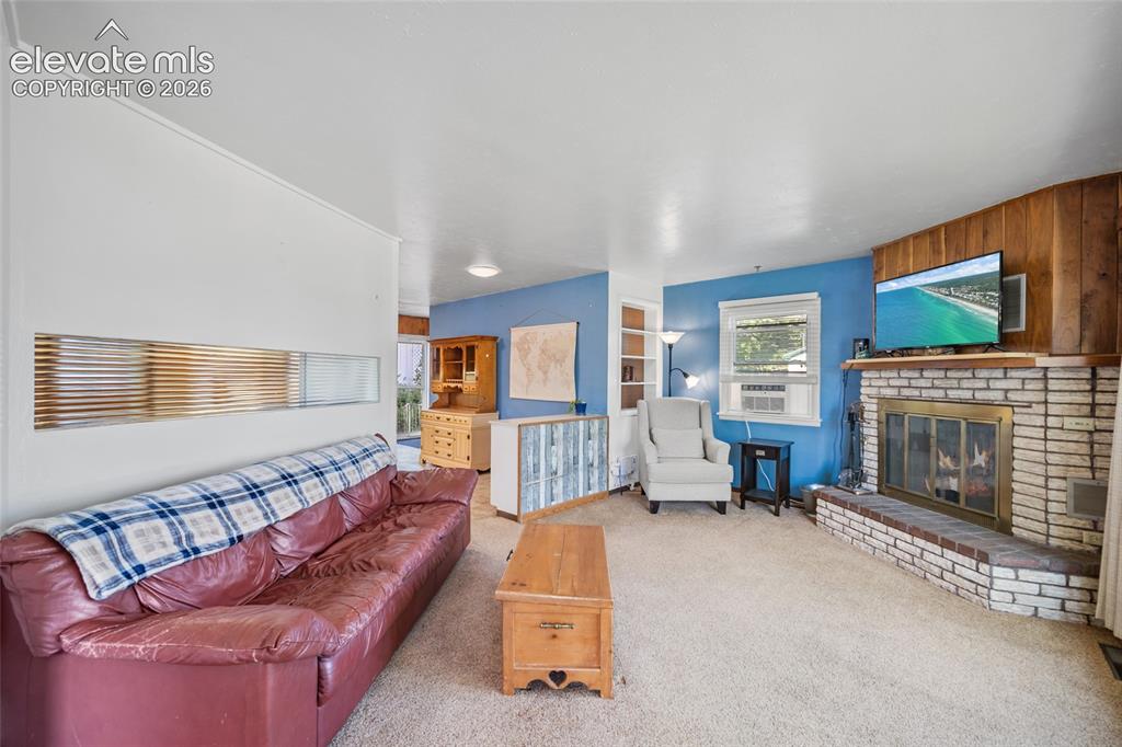 Image 4 of 41: Living Room with Built in Shelving and Wood-Burning Fireplace