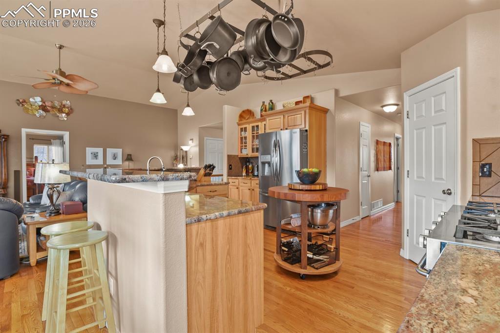 Image 13 of 42: Kitchen area  featuring light wood finish cabinets some with glass doors, g