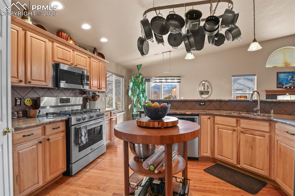 Image 16 of 42: Kitchen featuring tasteful backsplash, stainless steel appliances, dark sto