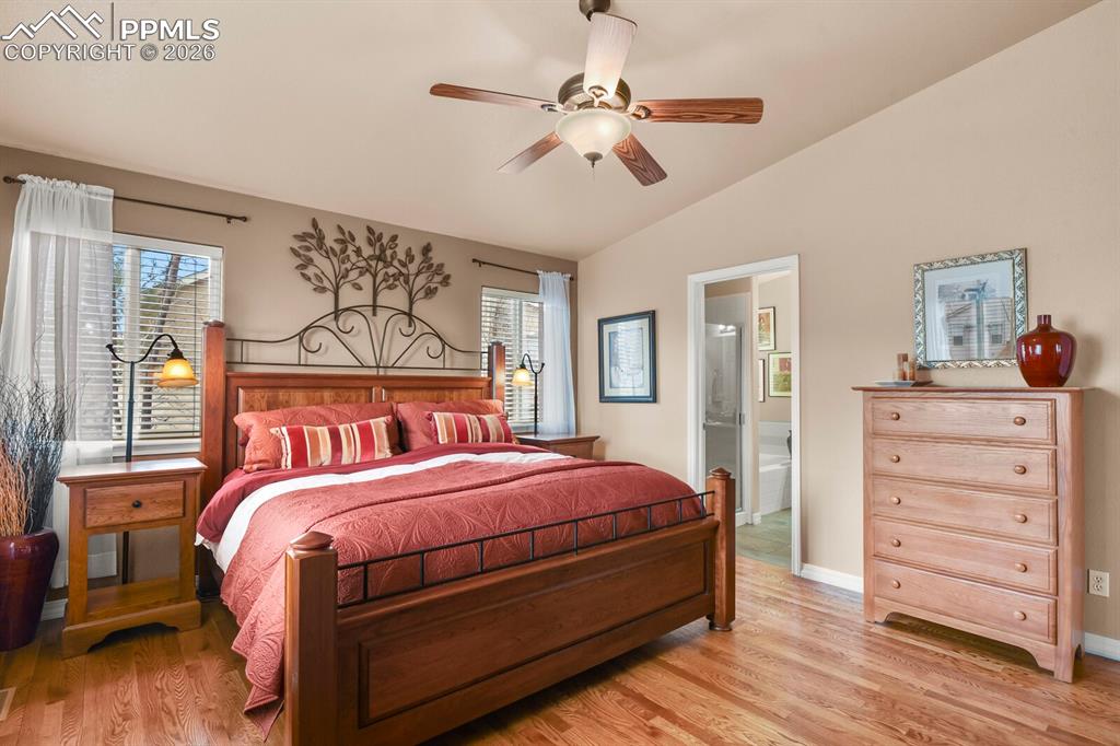 Image 18 of 42:  Primary Bedroom featuring hardwood floors, lofted ceiling, ceiling fan, an