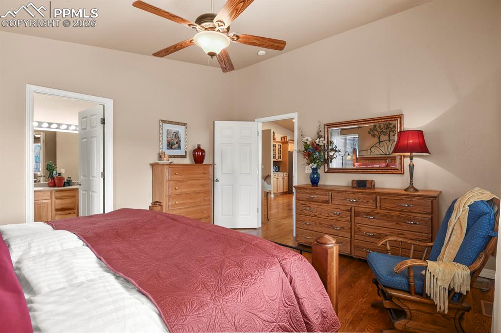 Image 19 of 42: Bedroom featuring wood finished floors, a ceiling fan, and ensuite bathroom