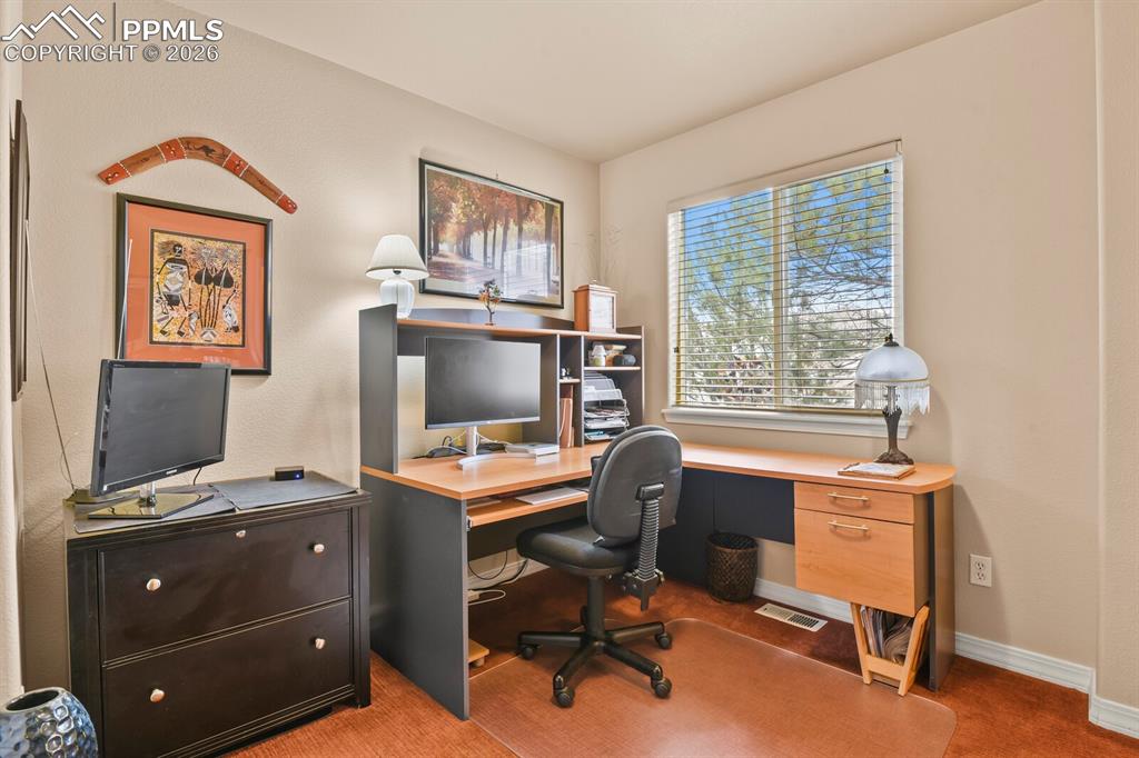 Image 24 of 42: Second bedroom on the main level, currently used as an office.  Faces to th