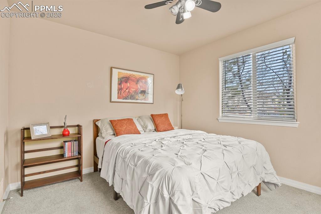 Image 25 of 42: 3rd bedroom on the main level featuring light carpet and ceiling fan